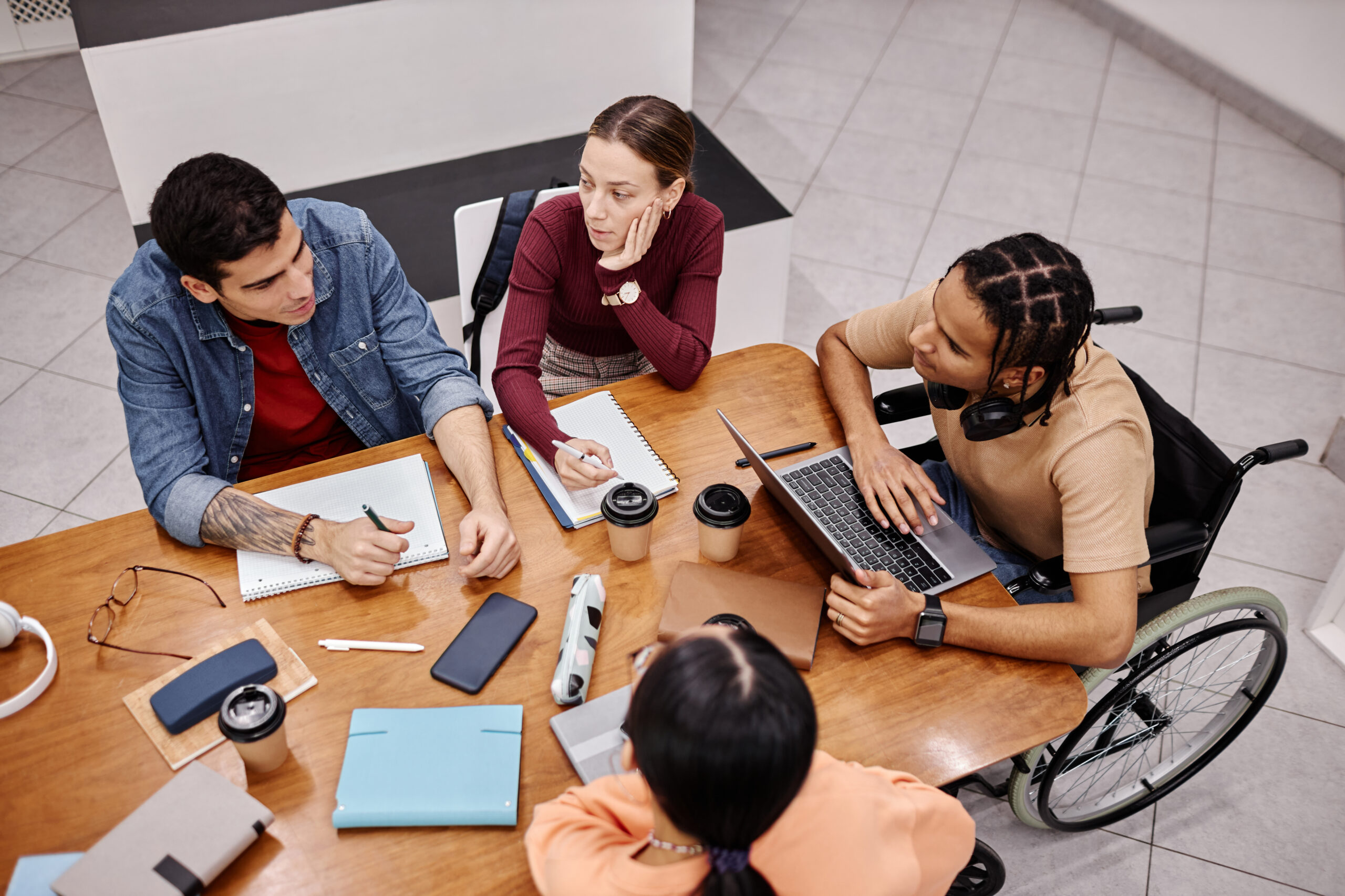 Inclusive team in a productive work session, with one member in a wheelchair.